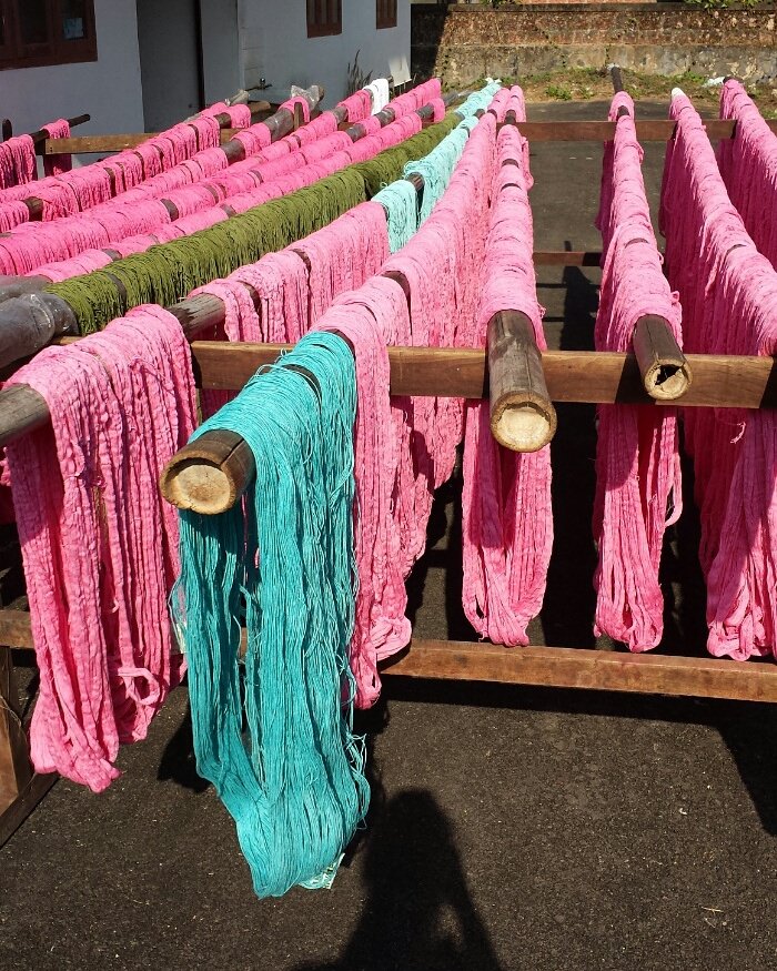 Once the yarn is fully dyed, the workers take the bamboo poles and place them outside.